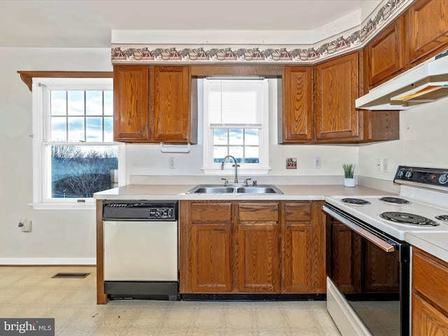 kitchen featuring light countertops, range with electric stovetop, white dishwasher, and light floors