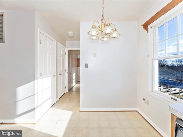 dining room featuring baseboards, a notable chandelier, and light floors