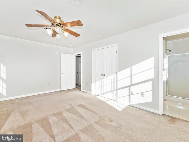 unfurnished bedroom featuring multiple closets, light carpet, and baseboards