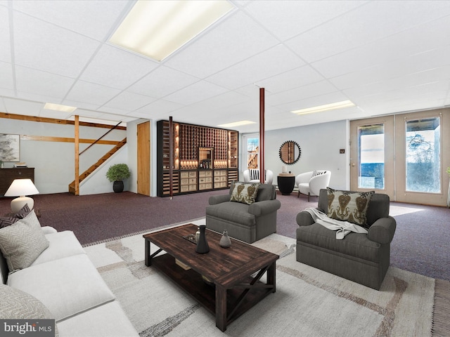 living room with light carpet, stairs, a drop ceiling, and french doors