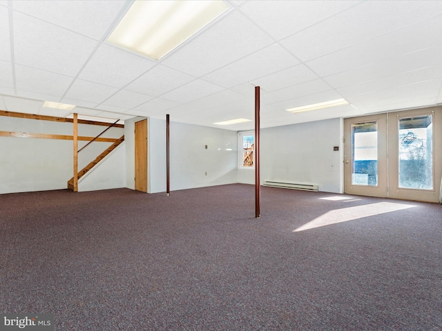 basement with carpet floors, french doors, a baseboard radiator, and a paneled ceiling