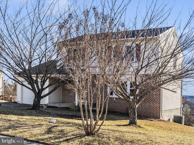 view of side of home featuring brick siding and a yard