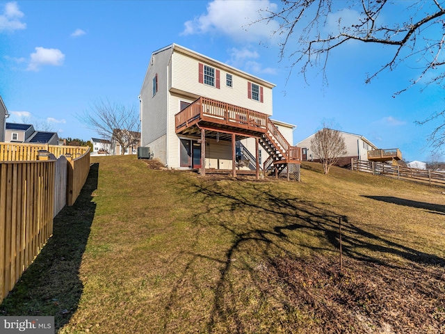 rear view of property featuring a deck, central AC unit, fence private yard, stairs, and a yard