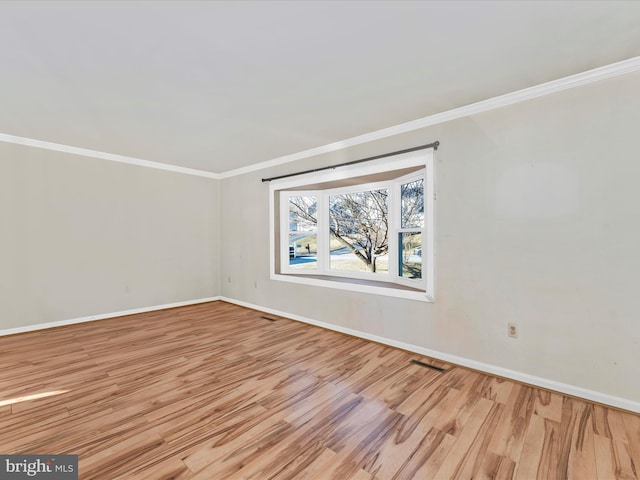 unfurnished room featuring light wood-style flooring, ornamental molding, and baseboards