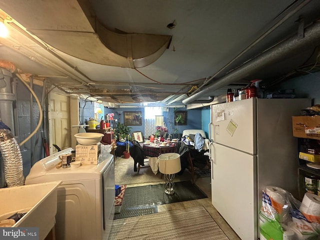 basement with white refrigerator, separate washer and dryer, and sink