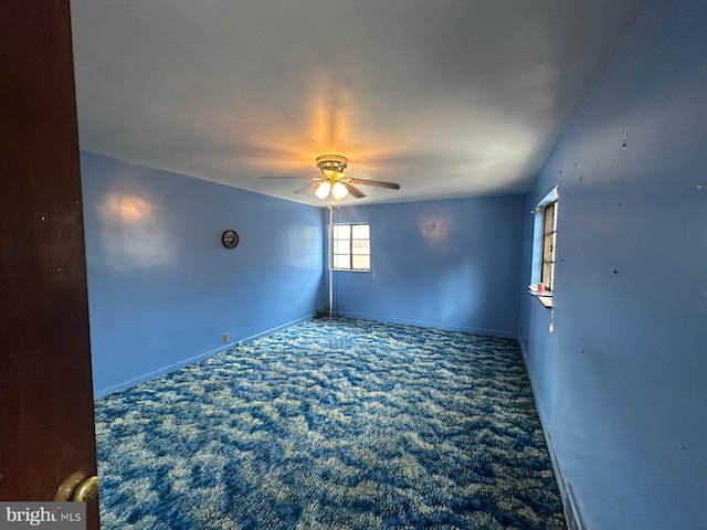 empty room featuring ceiling fan and carpet