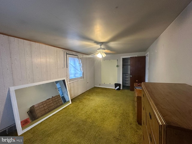 unfurnished living room featuring ceiling fan and carpet