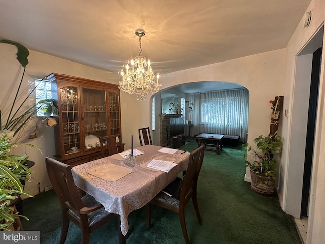 carpeted dining area featuring an inviting chandelier