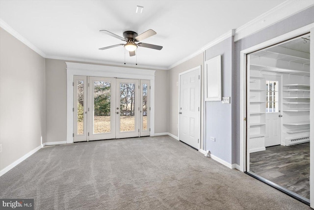 interior space with crown molding, light colored carpet, ceiling fan, and baseboard heating