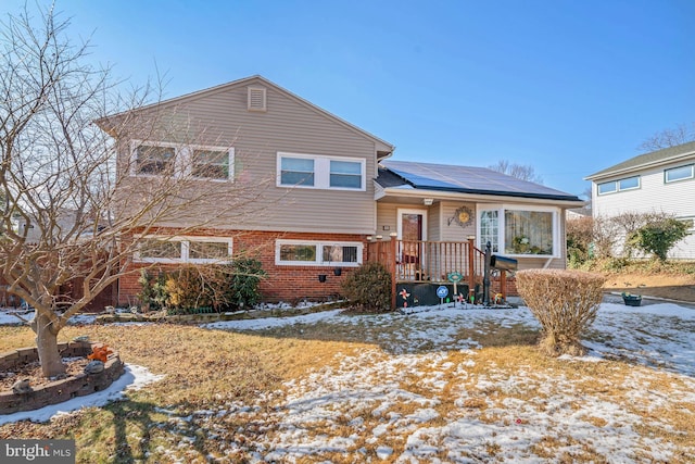 split level home featuring solar panels