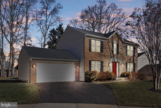 colonial-style house with a garage and a lawn