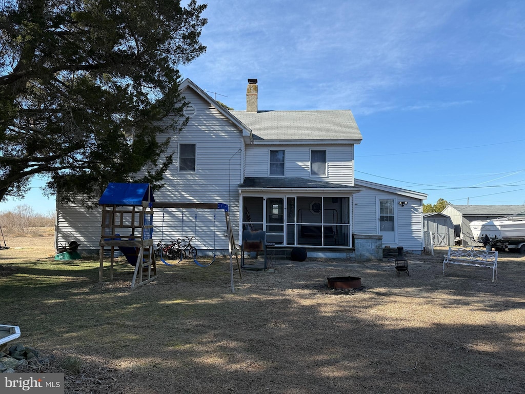 back of house featuring a yard and a sunroom