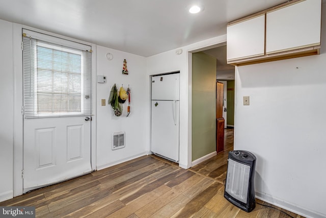 interior space with dark hardwood / wood-style flooring and heating unit