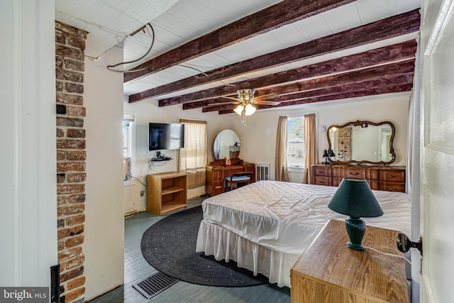 bedroom featuring multiple windows, hardwood / wood-style flooring, and beam ceiling