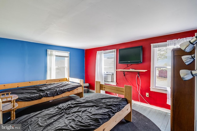 bedroom with cooling unit and wood-type flooring