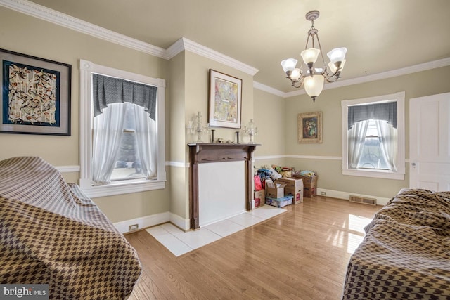 living area featuring light wood-style floors, baseboards, visible vents, and crown molding