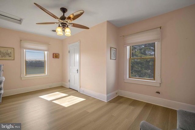 foyer with plenty of natural light, baseboards, and light wood-style flooring