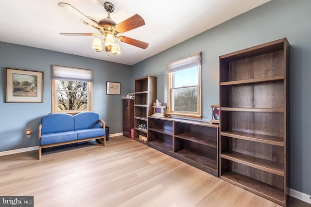 sitting room with baseboards, plenty of natural light, light wood finished floors, and ceiling fan