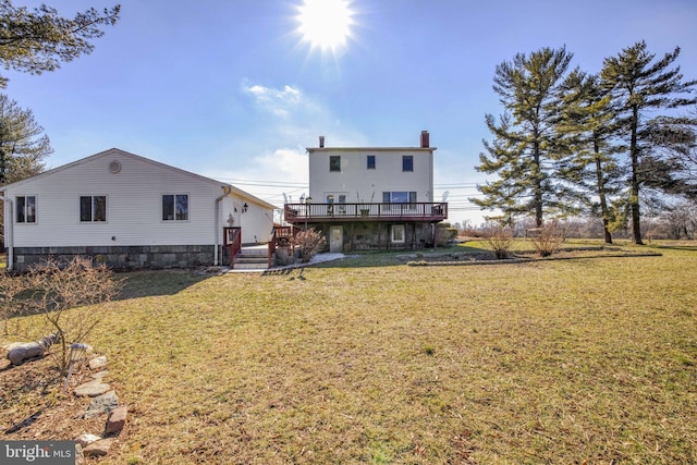 back of property with a wooden deck and a yard