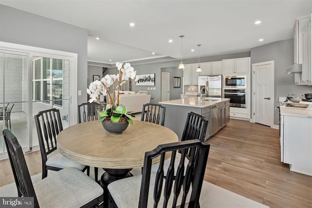 dining area with sink and light wood-type flooring