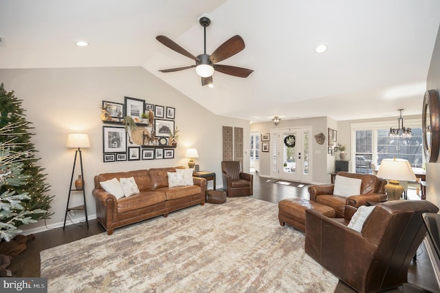 living room with hardwood / wood-style flooring, lofted ceiling, and ceiling fan with notable chandelier