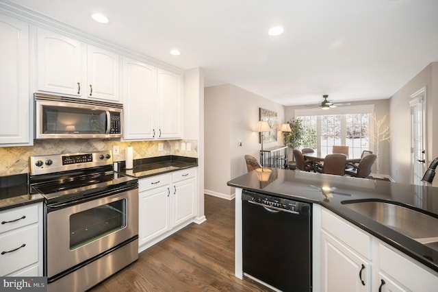 kitchen with sink, dark wood-type flooring, appliances with stainless steel finishes, tasteful backsplash, and white cabinets