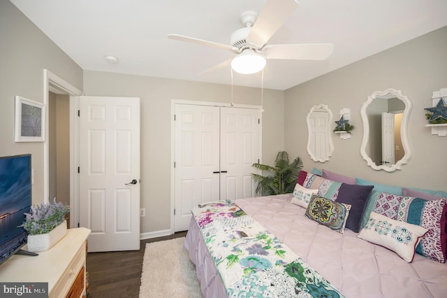 bedroom with dark hardwood / wood-style floors, a closet, and ceiling fan