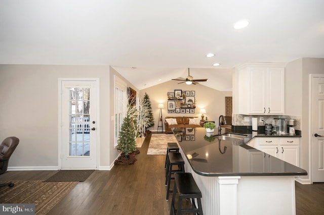 kitchen with sink, a breakfast bar area, kitchen peninsula, and white cabinets