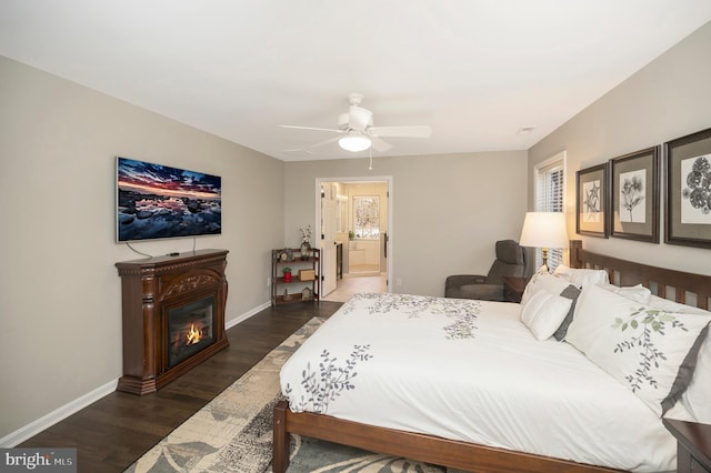 bedroom featuring ceiling fan, ensuite bathroom, and dark hardwood / wood-style flooring