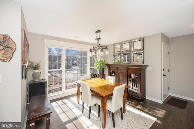 dining room with hardwood / wood-style floors and an inviting chandelier