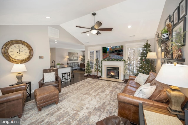 living room featuring hardwood / wood-style flooring, lofted ceiling, and ceiling fan