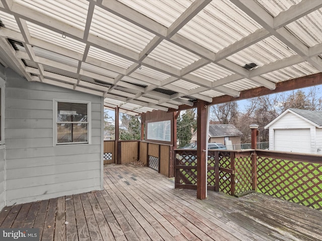 wooden terrace featuring an outbuilding and a garage