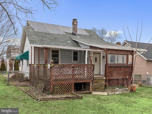 rear view of property featuring a lawn