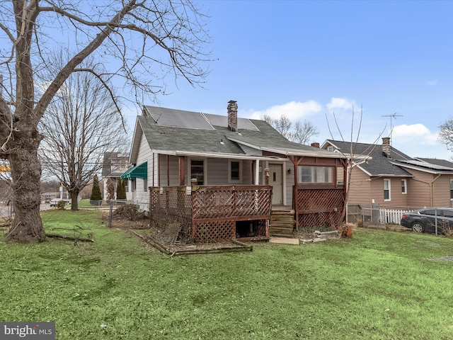 rear view of property with a yard and a deck