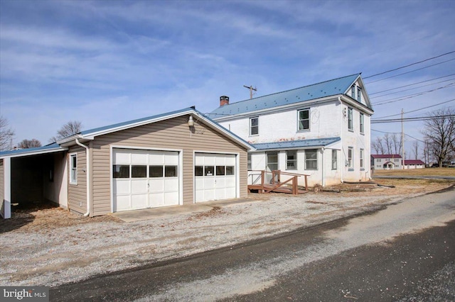 view of front of home with a garage and a carport