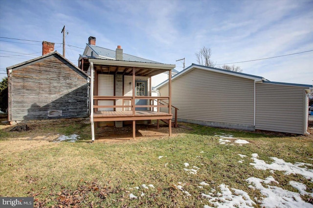 rear view of property featuring a lawn