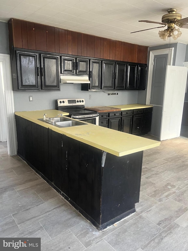 kitchen featuring sink, a breakfast bar area, electric range, ceiling fan, and kitchen peninsula