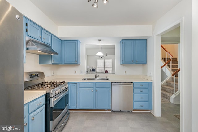 kitchen featuring sink, decorative light fixtures, blue cabinetry, and appliances with stainless steel finishes