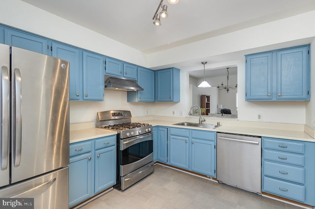 kitchen featuring pendant lighting, stainless steel appliances, blue cabinets, and sink