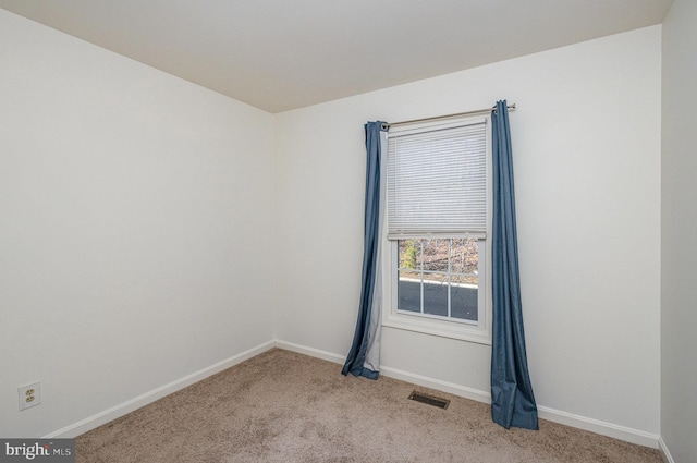 spare room featuring light carpet