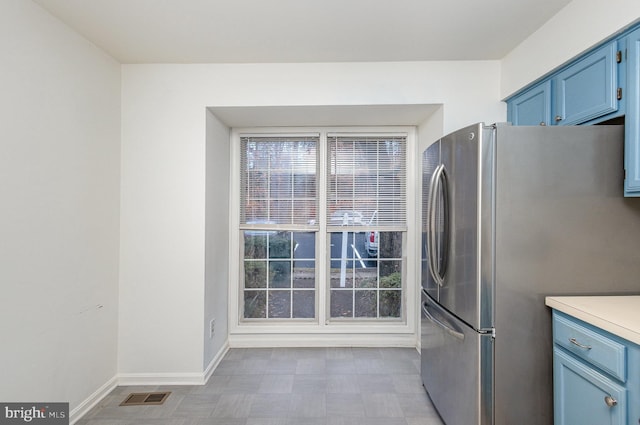 kitchen featuring blue cabinetry and stainless steel fridge