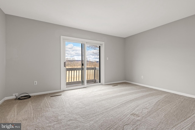 empty room featuring carpet, visible vents, and baseboards