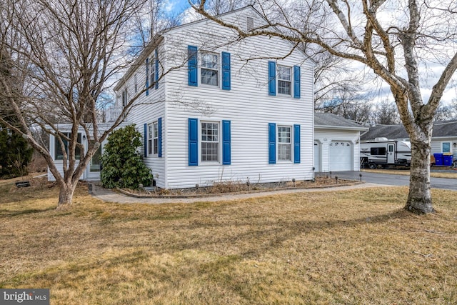 view of front of house featuring driveway, an attached garage, and a front yard