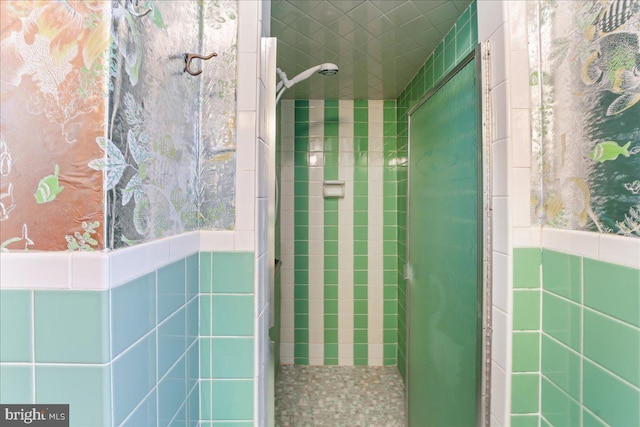 bathroom with tile walls and tiled shower