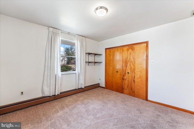 unfurnished bedroom featuring carpet, a closet, and baseboard heating