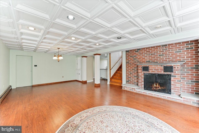 unfurnished living room featuring hardwood / wood-style floors and a brick fireplace