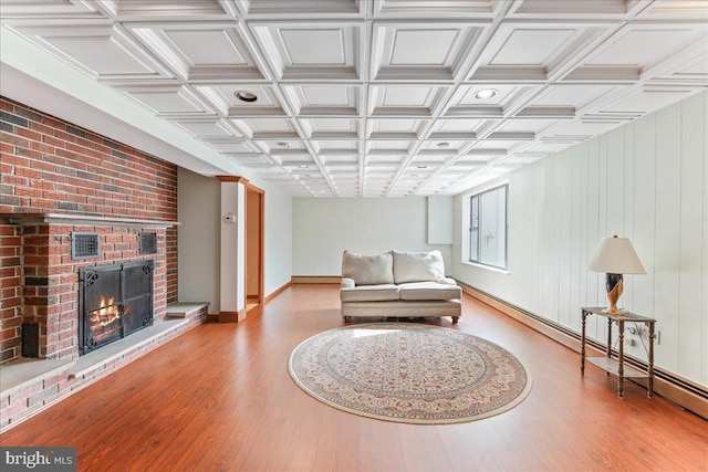 sitting room featuring light wood-type flooring, a fireplace, and baseboard heating