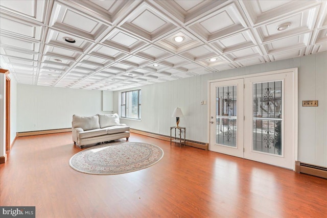 sitting room with a baseboard heating unit and wood-type flooring