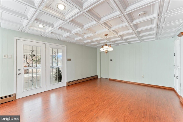 empty room featuring hardwood / wood-style flooring, a baseboard radiator, and coffered ceiling