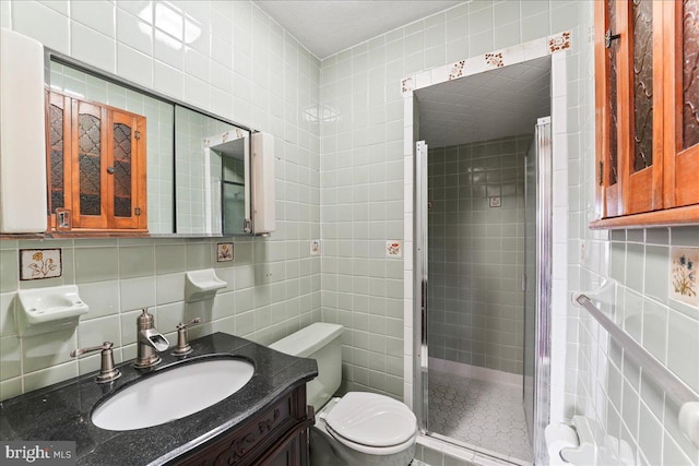 bathroom with toilet, tile walls, a tile shower, vanity, and decorative backsplash